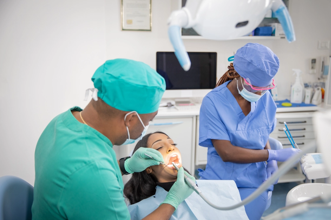 Dentist treating patient with dental assistant.