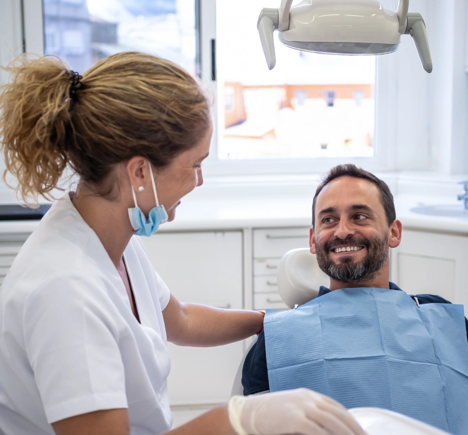 Rectangle 59 (2) Dentist smiling with patient in clinic.